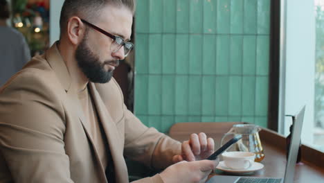 Hombre-De-Negocios-Usando-Un-Teléfono-Inteligente-En-Un-Café